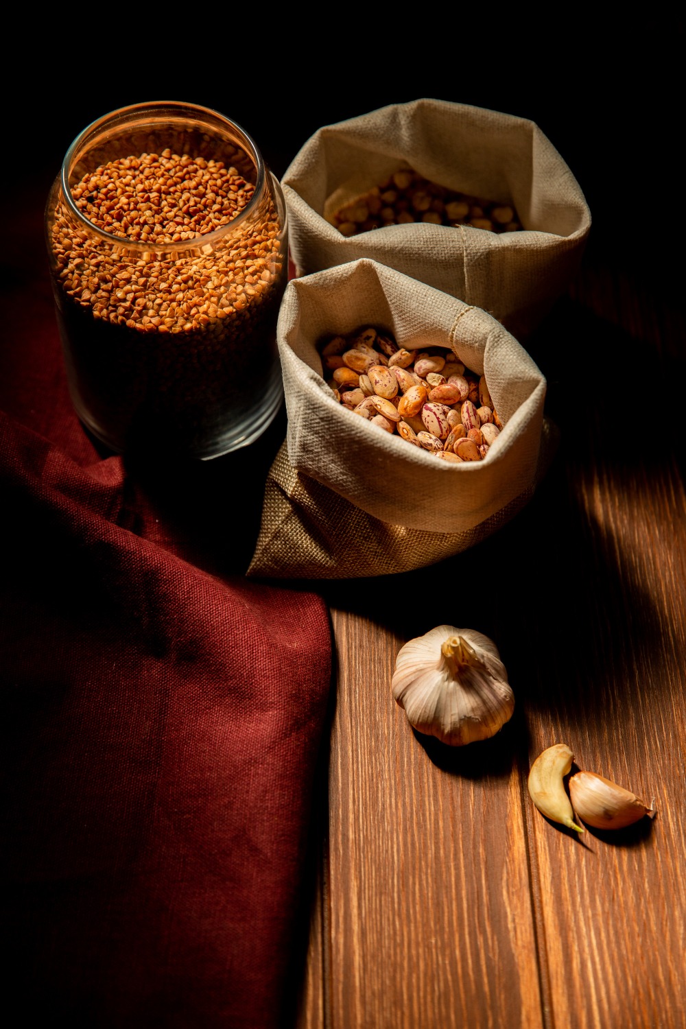 side-view-different-types-legumes-cereals-kidney-beans-buckwheat-chickpeas-sacks-dark-table